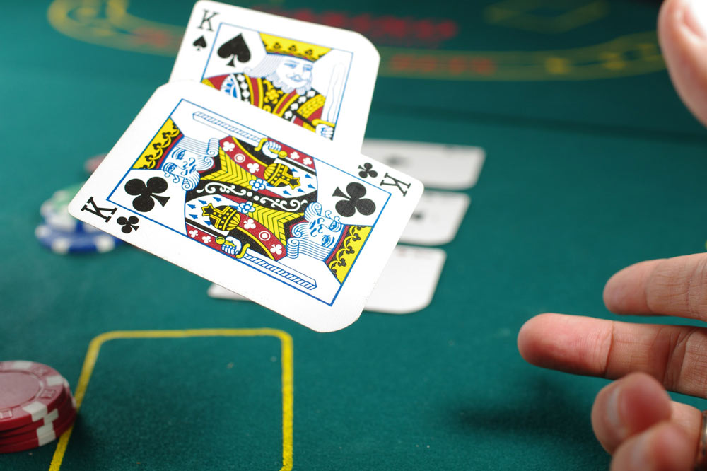 Pilha de fichas de cassino e royal flush baralho na mesa de poker verde