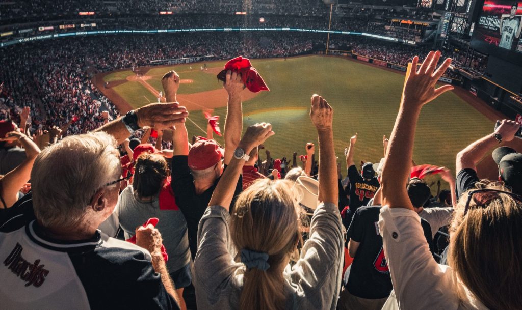 Fans watching a match in a stadium, cheering.