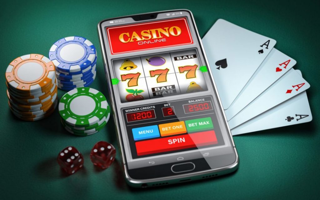 A phone with an Online Gambling slot on it surrounded by cards and chips